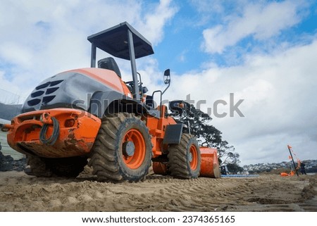 Bulldozer working on a sandy beach.
