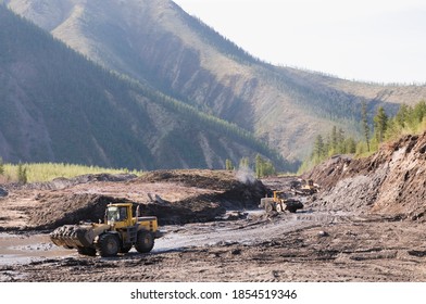     Bulldozers and wheel loaders at work. Mining.
Bulldozers cut the topsoil in mountainous forested areas and wheel loaders transport the soil