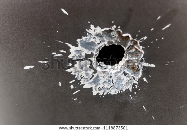 bullet hole in armored metal plate, war conflict\
and military tragedy\
concept