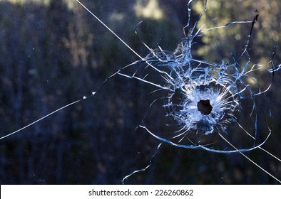 Bullet hole in a dirty glass window
