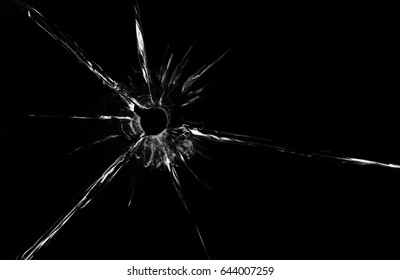 bullet hole in glass closeup on black background