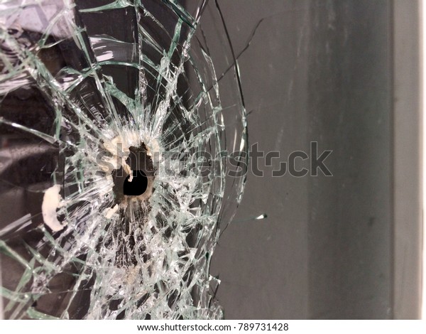 bullet hole on the glass window. cracked window\
after shooting