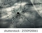 A bullet hole in the window of the house. Military and terrorist actions and the risk to the civilian population