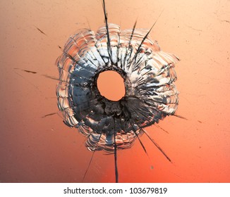 Bullet Hole In Window On The Background Sunset Sky