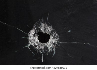 bullet holes in glass isolated on black