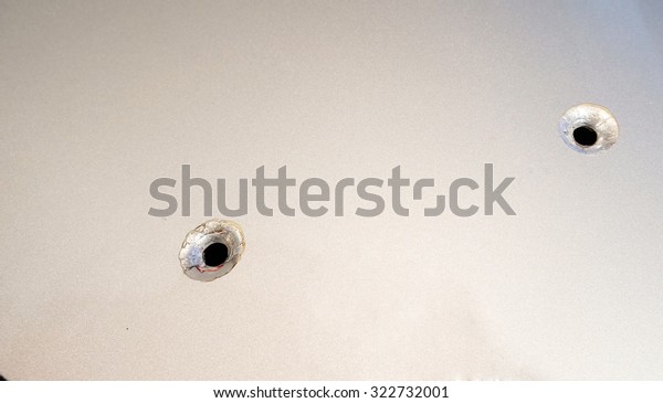 Bullet holes in metal\
sheet