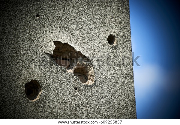 Bullet holes on building wall in\
Sarajevo, Bosnia and Herzegovina. Vignetting effect\
added