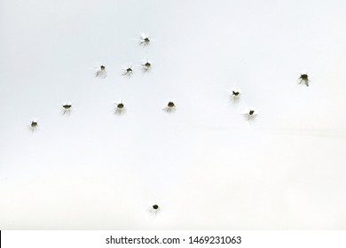 Bullet Holes On A White Sheet Of Paper, View From The Inside, Gunshot Damage, Abstract Background.