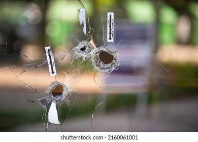 Bullet Holes On The Window Of Local Restaurant, Shot During War Shooting. Cracks Spreading Around Holes. Forensics Investigation Marks And Traces On The Glass.