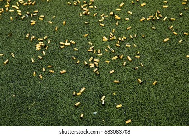 Bullet Shells Ground. Cases Of Bullets Lying On The Floor Of Artificial Grass