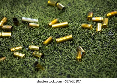 Bullet Shells Ground. Cases Of Bullets Lying On The Floor Of Artificial Grass