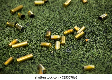 Bullet Shells Ground. Cases Of Bullets Lying On The Floor Of Artificial Grass