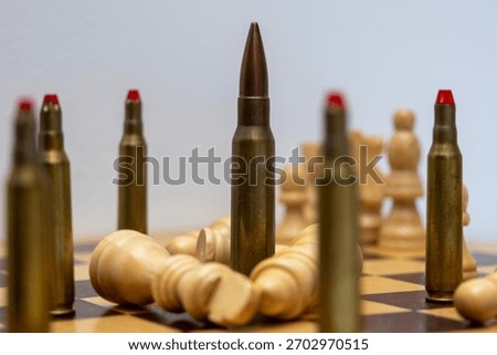 A bullet stands between fallen chess pieces, symbolizing conflict, tension, and disrupted strategy. The composition uses contrast and placement to emphasize thematic storytelling.