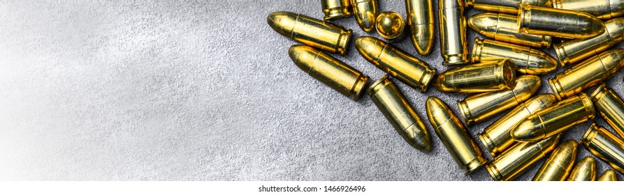 Bullets ammunition on stone table wide banner or panorama. Bullet pile background copy space.  Magazines, rounds and ammo military technology.