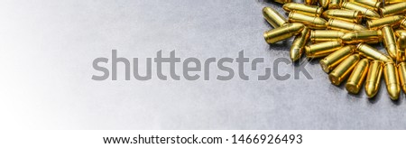 Bullets ammunition on stone table wide banner or panorama. Bullet pile background copy space.  Magazines, rounds and ammo military technology.