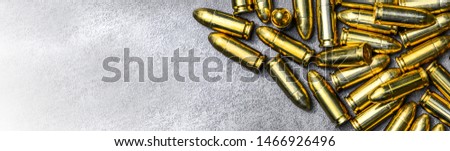 Bullets ammunition on stone table wide banner or panorama. Bullet pile background copy space.  Magazines, rounds and ammo military technology.
