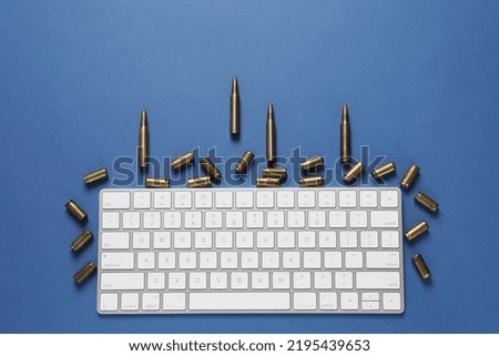 Bullets and computer keyboard on blue background, flat lay. Hybrid warfare concept
