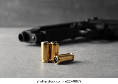 Bullets And Gun On Gray Table