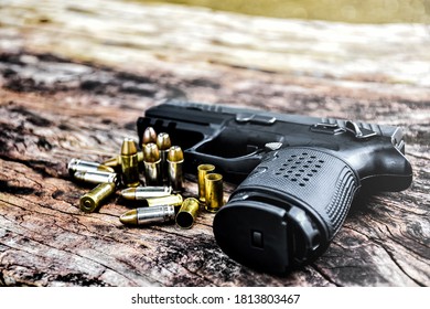 Bullets, Used Bullet Shells And Black Automatic Pistol On Old Wooden Floor.