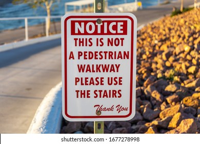 Bullhead, AZ / USA – February 19, 2020: Sign posted of – Notice This is not a Pedestrian Walkway – Please Use The Stairs, in red letter located in Bullhead City, Arizona.
