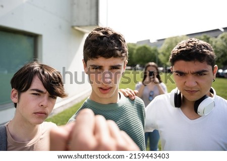 Bullied person view of aggressive friends menacing. Bullying and violence on teenagers concept.