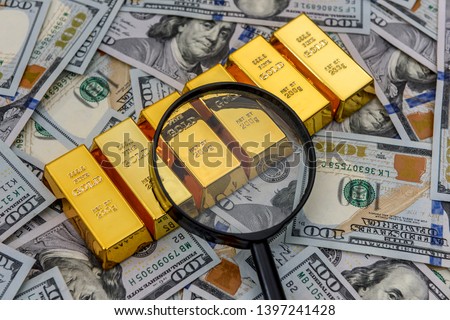 Bullion, gold or ingot on US dollar banknote with magnifier