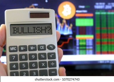 Bullish Message On The Calculator With The Background Of Trading Chart Of Bitcoin.  The Concept Of Bitcoin Price Direction Analysis