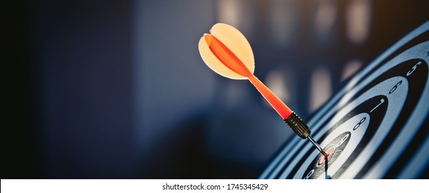 Bullseye or dart board has dart arrow throw hitting the center of a shooting target for business targeting and winning goals business concepts. - Shutterstock ID 1745345429
