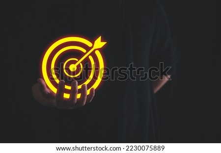 Bullseye is a target of business. Dart is an opportunity and Dartboard is the target and goal. So both of that represent a challenge in business marketing as concept. a man holding target icon.