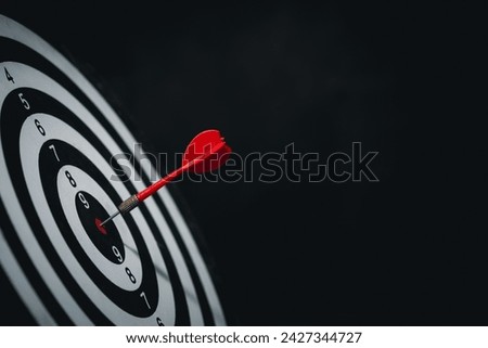 Bullseye is a target of business. Dart is an opportunity and Dartboard is the target and goal. challenge in business marketing business success concept. Dark black background. Cpoy space for text.