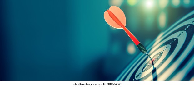 bullseye target or dart board has red dart arrow throw hitting the center of a shooting for business targeting and winning goals business concepts. - Shutterstock ID 1878866920