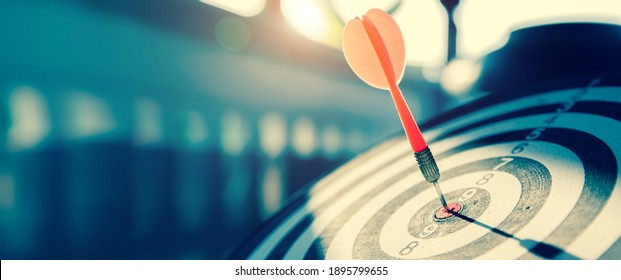 bullseye target or dart board has red dart arrow throw hitting the center of a shooting for business targeting and winning goals business concepts. - Shutterstock ID 1895799655