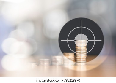 BULLSEYE TARGET RIGHT AT THE HIGHEST STACKED US QUARTER COINS WITH NICE BOKEH OF LIGHT AND COPY SPACE / FINANCIAL CONCEPT