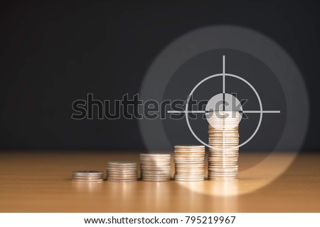 BULLSEYE TARGET RIGHT AT THE HIGHEST STACKED US QUARTER COINS WITH COPY SPACE / FINANCIAL CONCEPT