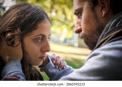 Bully and abuser, a jealous boyfriend abuses his girl girlfriend, verbally and physically threatens, yells at her and scares her, outdoor in public park. Domestic violence concept