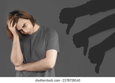 Bullying Concept With Silhouette Thumb Down. Sad Young Man. The Guy Keeps His Hand On His Head, Upset. Cancel Culture, Calling-out, Toxic Behaviours. Psychological Pressure, Stress, Crisis.