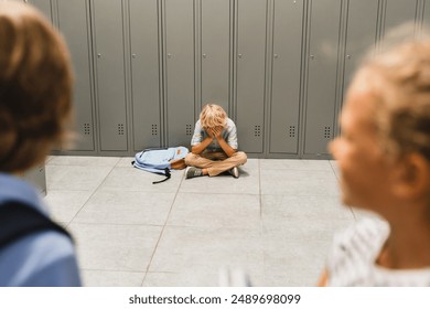 Bullying at school between teenagers. Lonely sad boy crying sitting on the school floor. Torturing, social exclusion concept. Puberty difficult age - Powered by Shutterstock