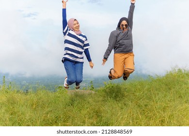 Bulukumba, Indonesia -january 20 2022 :happy women traveling and jumping together in mountains. at the peak of ma ra sinjai