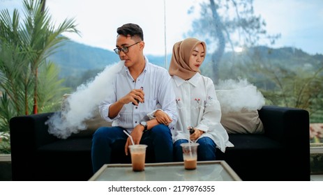 Bumijawa , Indonesia - May 22 , 2022
romantic couple by smoking vape