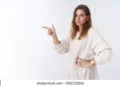 Bummer shame missed opportunity. Portrait upset regret good-looking woman standing profile pointing index finger sideways turning camera pursing lips gloomy smile disappointed, lose chance