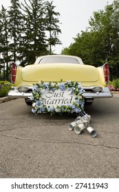 Bumper Of Limousine With Just Married Sign And Cans Attached