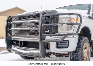 Bumper Of White Vehicle With Black Grille Guard Against Building And Cloudy Sky