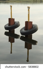Bumpers -- old tires -- on steel pilings to prevent damage to small craft in marina - Shutterstock ID 5838802