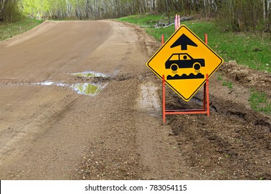 A bumpy road ahead sign with a large pothole.