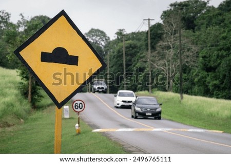 bumpy road ahead sign, speed bump traffic sign, on road in green forest park, Khao Yai National Park, Thailand