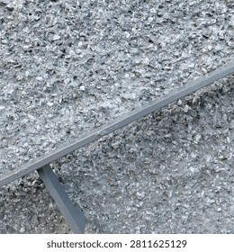 A bumpy wall finished with small stones and iron railing