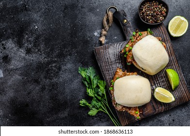 Bun bao steamed with pork belly and vegetables. Black background. Top view. Copy space