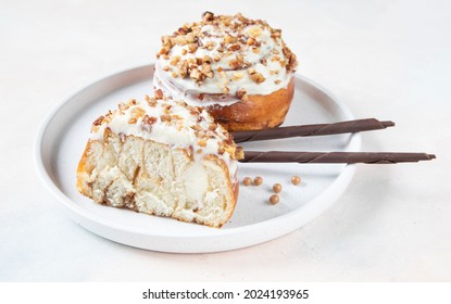 A Bun In The Form Of A Snail With Curls Of Dough With Tender Butter Cream, Walnuts And Icing On Top. The Delicious Dessert Is Decorated With Two Sticks Of Milk Chocolate And Balls Of Salted Caramel