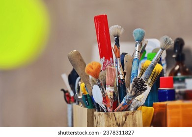 bunch of artist paintbrushes and tools in a jar - Powered by Shutterstock