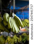 A bunch of bananas hanging at a fruit vendor